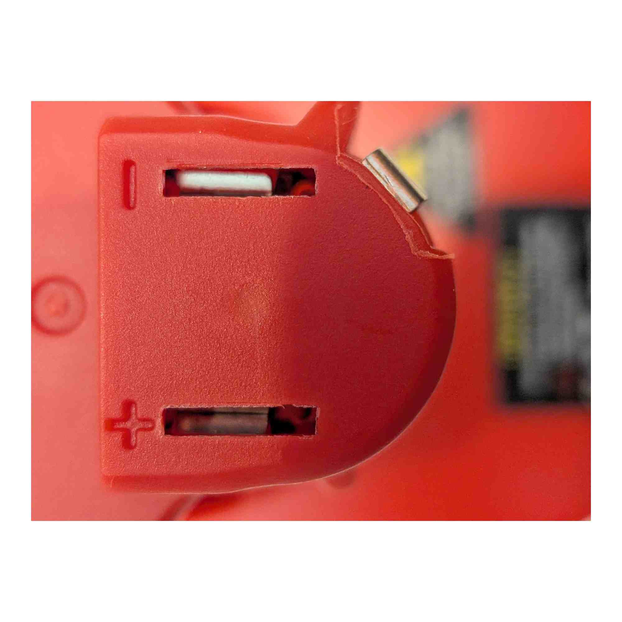 DeWalt 20V MAX to Milwaukee M12 battery adapter - close-up of the Milwaukee tool-side slots with moulded + and - marks
